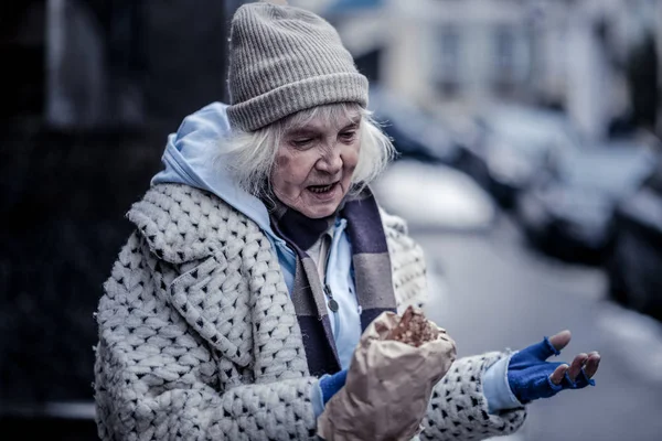 Bir çanta pasta ile tutan ponponsuz zavallı kadın — Stok fotoğraf