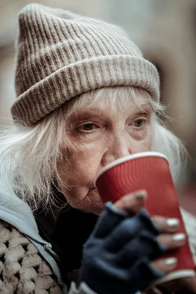一个贫穷的老年妇女喝热茶的肖像 — 图库照片