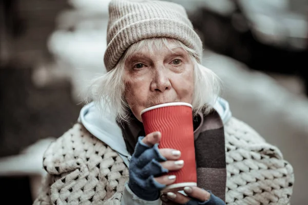 Sad poor woman standing with a cup of tea — Stock Photo, Image