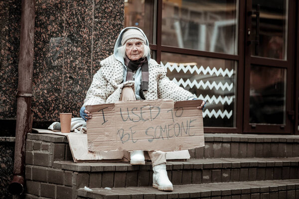 Несчастная депрессивная бездомная женщина с табличкой
