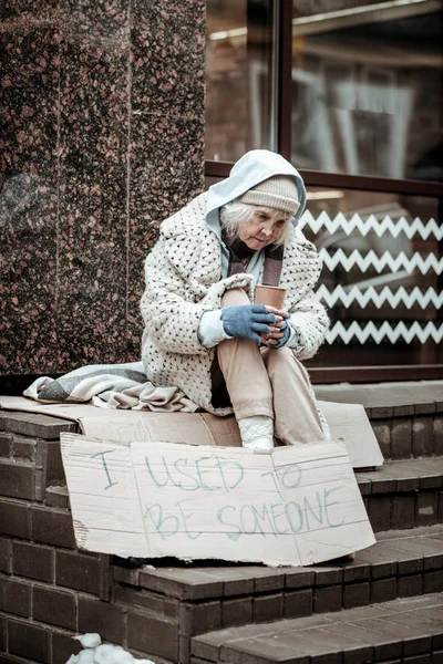 Neveselé věku žena žebrat o peníze na ulici — Stock fotografie
