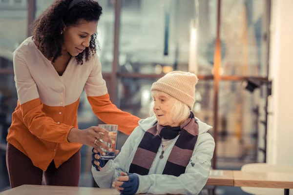 Nette ältere Frau nimmt ein Glas mit Wasser — Stockfoto