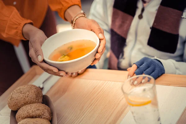 Tigela de sopa quente saborosa em mãos femininas — Fotografia de Stock