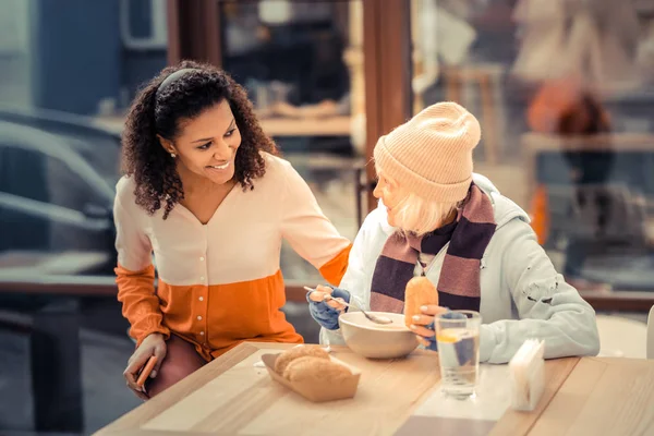 Mooie vrolijke vrouw helpt arme dakloze mensen — Stockfoto