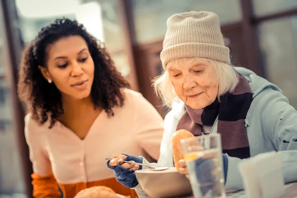 Nette Seniorin schaut auf ihr Essen — Stockfoto