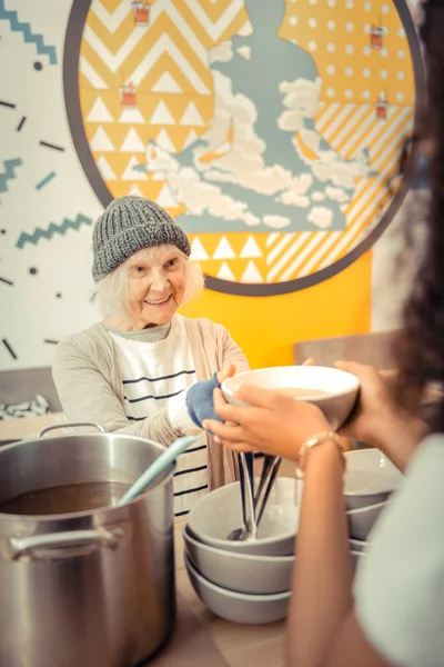 Nice senior woman waiting for the soup — Stock Photo, Image