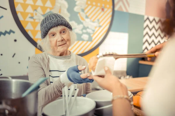 Arme hongerig vrouw kijken naar het voedsel — Stockfoto