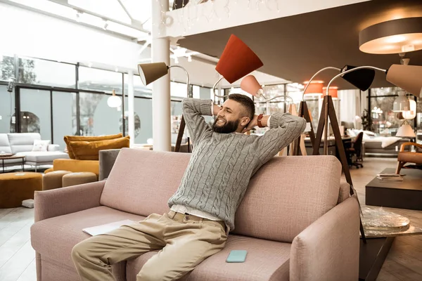 Joyful man being tired of shopping process and stretching up — Stock Photo, Image