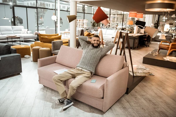 Ler man i grå tröja vila på soffan — Stockfoto