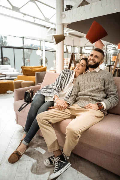 Excelente casal bonito sentado com sorrisos largos em seus rostos — Fotografia de Stock