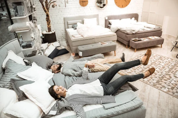 Cheerful pleasant family jumping right on bed surface