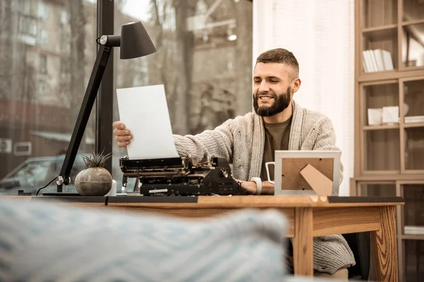 Smiling bearded writer being happy with his work