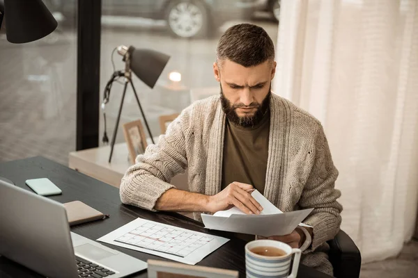 Hombre barbudo enfocado llenando su horario de trabajo — Foto de Stock