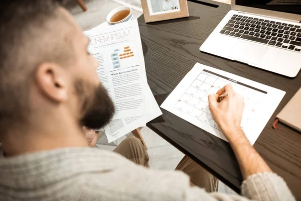 Verantwortungsbewusster, gut organisierter Mann füllt Kalender mit Affären — Stockfoto