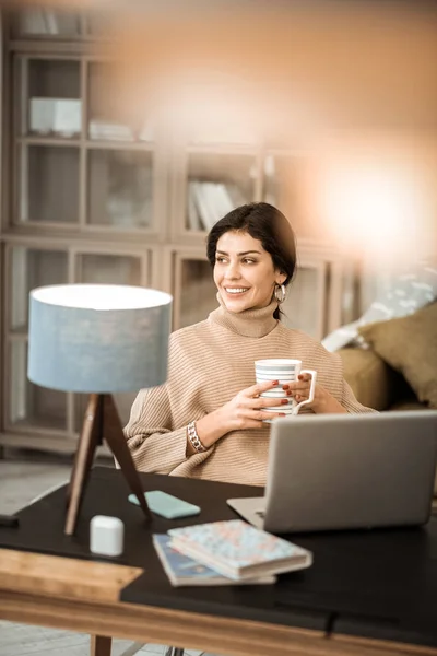 Beautiful peaceful lady in beige knitted sweater in home cabinet — Stock Photo, Image