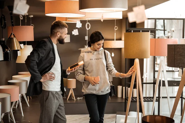 Mujer interesada tocando muebles colocados en el showroom — Foto de Stock