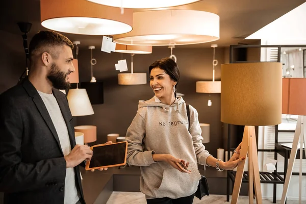 Señora riendo pasar tiempo en la tienda de muebles y la elección de muebles —  Fotos de Stock