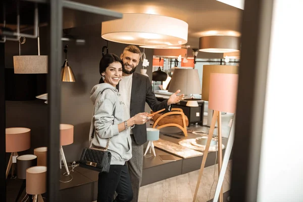 Senhora sorrindo positiva apreciando processo de compras na seção relâmpago — Fotografia de Stock