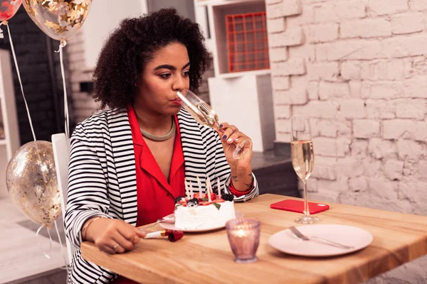 Nice cheerless young woman drinking champagne alone — Stock Photo, Image