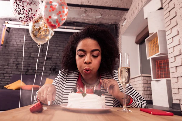 Pleasant afro american woman blowing at the candles — Stock Photo, Image