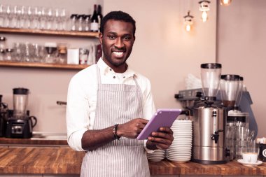 Modern bir tablet tutan olumlu neşeli adam