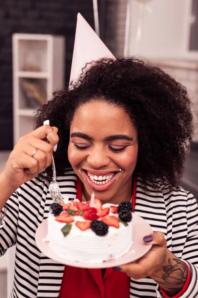 Positive hungry woman holding a plate with a cake — Stock Photo, Image