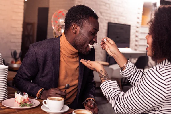 Encantado hombre positivo probando un pastel de su novia — Foto de Stock