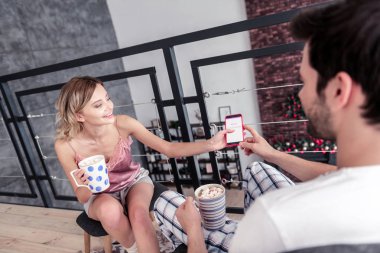 Koyu renk saçlı sakallı genç adam ciddi seyir beyaz tişört