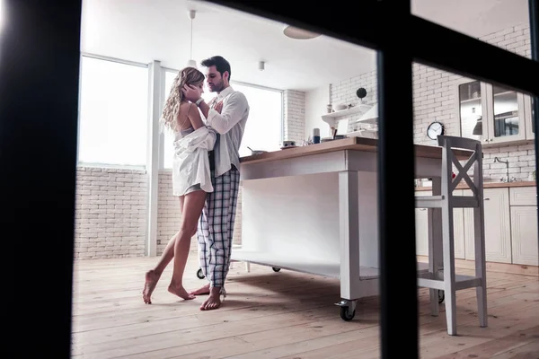 Dark-haired bearded man in a white shirt and his beautiful wife looking thoughtful — Stock Photo, Image