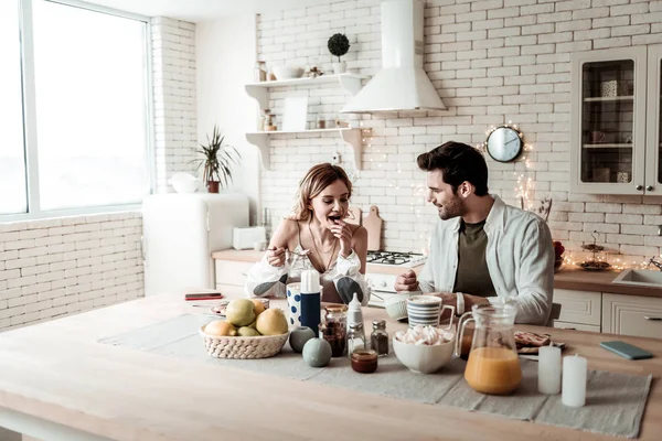 Ung långhåriga söt kvinna i vit skjorta och maken äter frukost tillsammans — Stockfoto