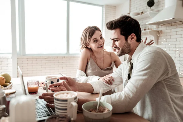 De pelo largo radiante mujer bonita en la ropa de casa viendo un video con su marido —  Fotos de Stock