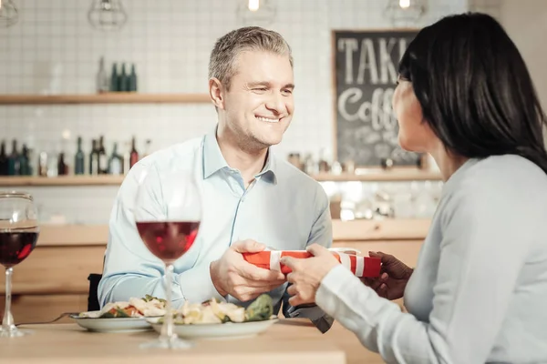 Pareja cariñosa intercambiando regalos en el restaurante — Foto de Stock