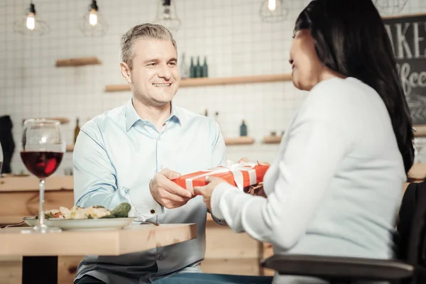 Thoughtful wife giving birthday present to husband