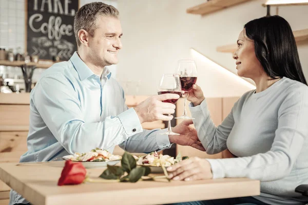 Hombre encantador y mujer feliz sosteniendo vasos de vino — Foto de Stock