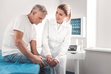 Düşme sonra bazı diz ağrısı olan kot giyen emekli