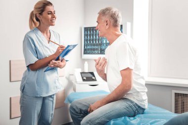 Sağlık görevlisi. Güzel sarışın sağlık görevlisi ziyaretçi ile iletişim tadını çıkarırken neşeli hissediyorum