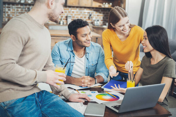 Веселые четверо коллег, представляющих планы
