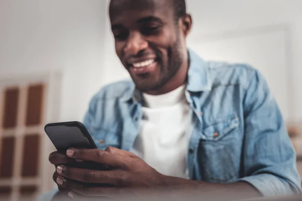 Nuevo teléfono inteligente estar en manos de un hombre alegre positivo — Foto de Stock