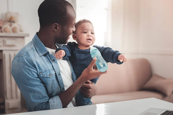 Vrolijke aangename man op zoek na zijn baby — Stockfoto