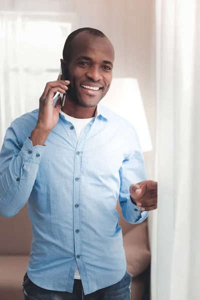 Hombre alegre positivo poniendo un teléfono a su oído — Foto de Stock