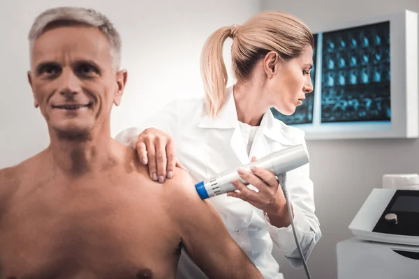 Bionda medico guardando roentgen di uomo anziano — Foto Stock