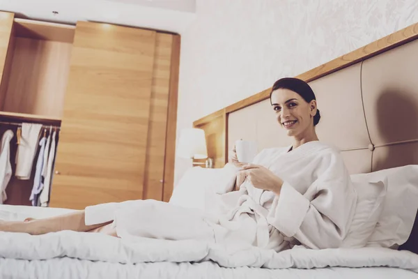 Радісна жінка розслабляється в спальні — стокове фото