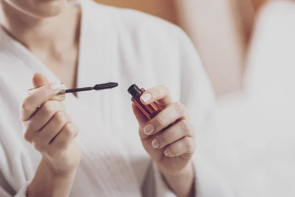 Frauenhände mit einer Flasche Wimperntusche — Stockfoto