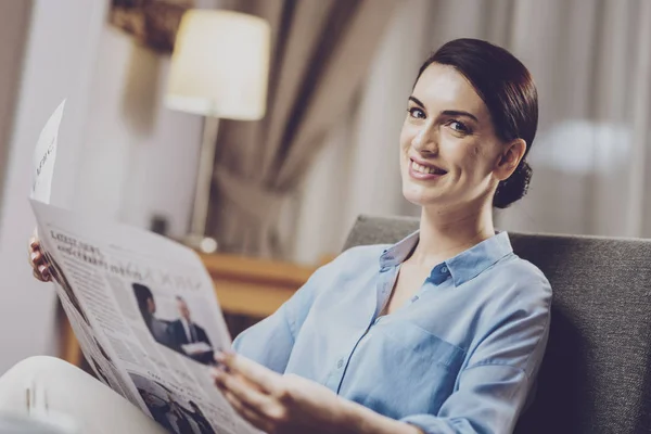 Charismatic businesswoman resting with coffee and newspaper