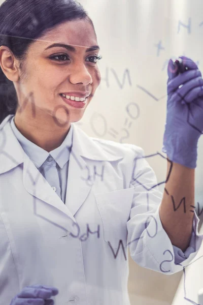 戴手套书写分子链的年轻化学家 — 图库照片