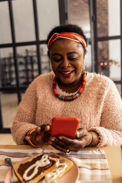 Mujer afroamericana encantada leyendo un mensaje — Foto de Stock