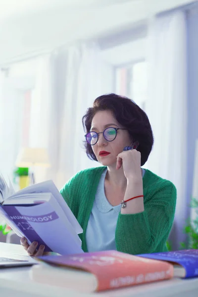 漂亮聪明的女人读一本关于数字学的书 — 图库照片