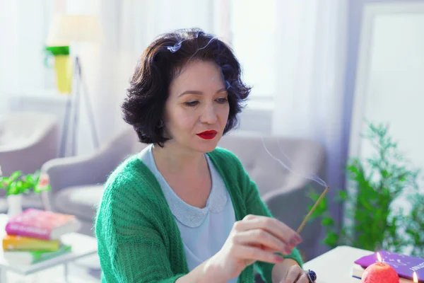 Nice dark haired woman holding an aroma stick — Stock Photo, Image