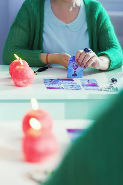 Nette, geschickte Wahrsagerin, die vor dem Spiegel eine Karte öffnet — Stockfoto