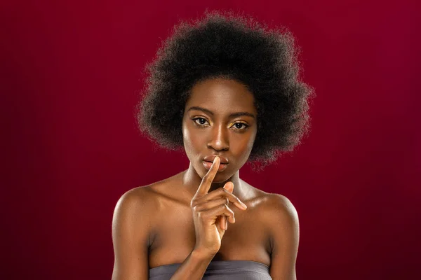 Angenehme junge Frau legt den Finger auf die Lippen — Stockfoto